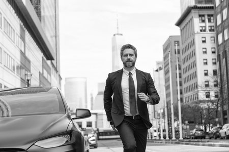 Successful businessman man running in a hurry to car dealer having dealership business outdoorの写真素材