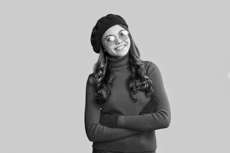 Autumn fashion girl. Trendy and stylish teenager girl smiling. Fall fashion style for teen. Complete outfit for the fall style. Girl in autumn beret. Teen girl isolated in yellow. Autumn accessoriesの写真素材