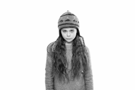 Winter fashion style. Stylish girl in winter hat. Teen child portrait wearing warm winter hat. Girl kid isolated on white. Childhood. Teen girl wearing knitted sweater. Knitted accessoriesの写真素材