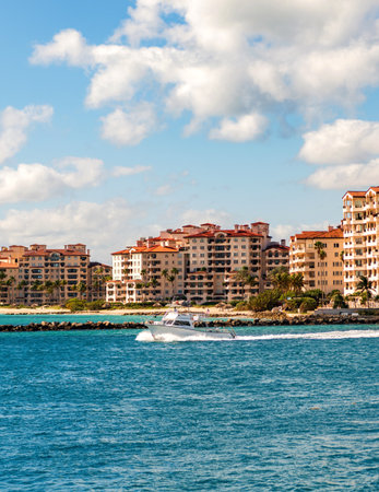 Luxury yacht boat at Fisher island. Summer vacation. Fisher island residential building and luxury yacht boat. Sunset view of Fisher island, Miami. Motor boat yacht floating to marinaの写真素材