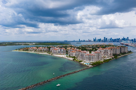 Aerial night view of Miami coastline. Twilight skyline above the Miami oceanfront. Miami Beach waterfront glowing after sunset. South Point lifeguard tower at dusk. Famous Miami Beach from above.の写真素材