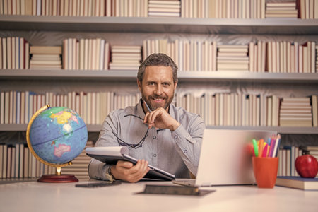 geographer teacher at school. Millennial school teacher of geography. Man teaching geography in class. teachers day. hispanic teacher with globe. school education. back to school. Quality educationの写真素材