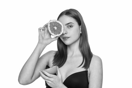 Woman fill skin with vitamin. Skincare and diet. Young girl has clean skin. Healthy lifestyle. Skin of beauty woman isolated on white. Beauty woman with grapefruit. Essential for overall skin healthの写真素材