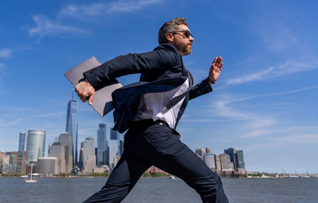 Business success. Successful businessman hurrying on New York city skyline. Business man in Manhattan. Business success in big city. Businessman running to success. Being lateの写真素材