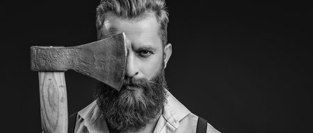 Brutal male fashion style. Male brutality. Vintage brutality guy with axe in retro suspenders. Brutal man in suspenders with ax isolated on black. Mature redhead man with hairstyle. Copy spaceの写真素材