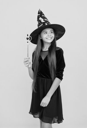 All Hallows witch. October 31. Teen girl in witch costume hold magic wand. Happy Halloween. Girl witch in Halloween costume. Trick or treat. All Hallows party. November holidayの写真素材