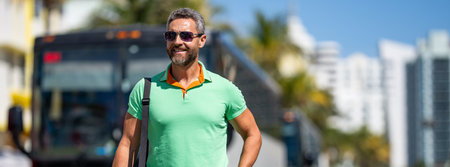 Traveler trip luggage. Summer tour. Traveler enjoy summer trip. Hispanic tourist traveler walking on street. Tourist with suitcase in tropical city. Man 40s tourist on summer vacation. Copy spaceの写真素材