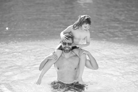 Son child having fun with his father. Pool time. Fathers day. Parenthood. Summer vacation of happy family. Father and son in swimming pool. Travel in summer. Sea beach vacation. Cruise vacationの写真素材