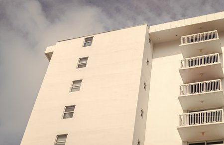 Residential white building architecture. Architectural exterior. House exterior fragment. Modern apartment building facade. Apartment building with exterior detail. View of building facadeの写真素材