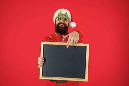 Santa man hold advertisement. New Year man offer holiday shopping. Xmas sale, copy space. Shopping sale and discount for Christmas. Happy New Year. Sale offer for Christmas holiday. Seasonal goodwillの写真素材