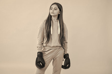 proud teen girl boxer learn punching at sport training in active wear for boxing govesの写真素材