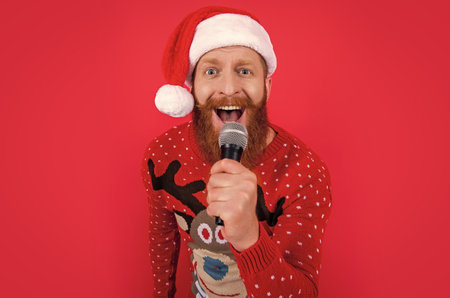 christmas music party. amazed man at christmas music party with microphone. christmas santa manの写真素材