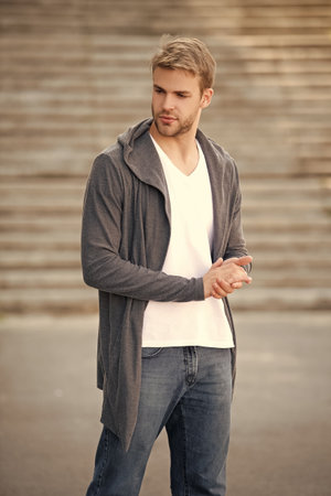 Young millennial man outdoor. Stylish man portrait. Casual style menswear of man. Guy has stylish menswear. Man with trendy hoodie. Casual male style portrait. Millennial portraitの写真素材
