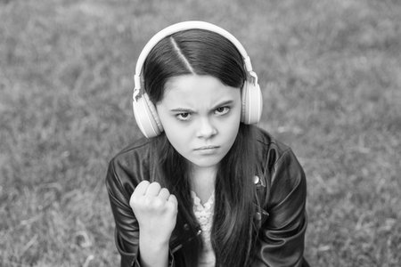 Teen girl listen music in wireless headphones and threatening outdoor. Gen z lifestyle. Style of music. Stylish teen girl listen music. School student lifestyle. Listen audio. Music lifestyle. Angerの写真素材