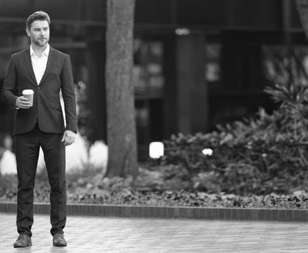 Businessman outdoor. Business man at coffee break. Businessman with coffee cup outdoor, copy space. Successful man after business meeting. Business of businessman. Coffee breakの写真素材