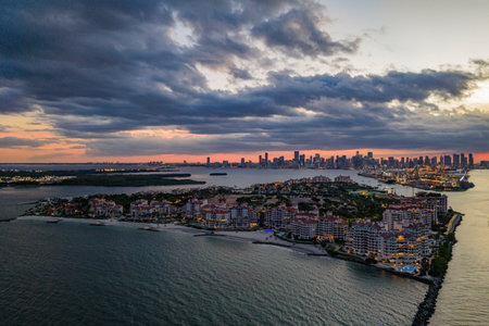 Aerial night view of Miami coastline. Twilight skyline above the Miami oceanfront. Miami Beach waterfront with dramatic sky.の写真素材