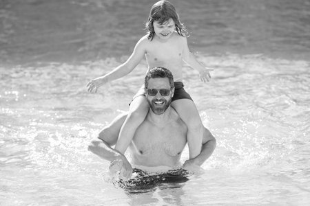 Father son beach adventure. Family bonding of father and son. Family day with dad and son. Father with kid in swimming pool. Fatherhood at summer vacation. Summer vacation at pool. Travel destinationの写真素材
