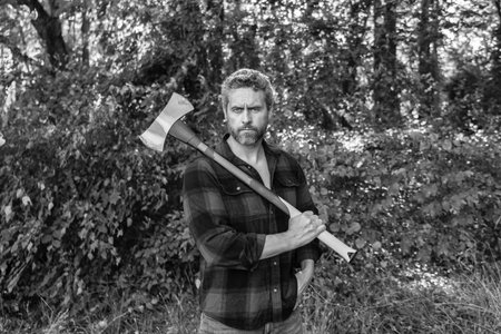 Lumberjack hardworking outdoor. Brutal lumberjack. Brutality and masculinity. Hispanic lumberjack man with axe. Lumberjack axe. Man with logging axe. Hardworking brutal manの写真素材
