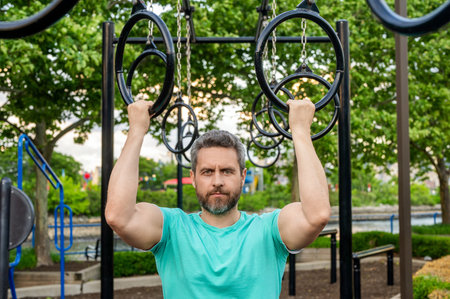 Man pullup at outdoor gym. Muscular man sportsman with strong hands. Sport pullup workout. Sport...