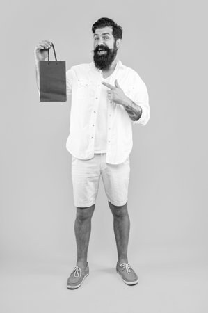 shopping man on background, pointing finger. photo of shopping man with bags.の写真素材