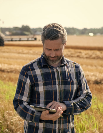 Farmer man working on field with tablet. Hispanic farmer with tablet check harvest. Crop harvest....
