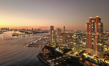 Aerial panoramic view on skyscraper cityscape at night. Night city aerial. Luxury skyscraper in Miami, Florida. City skyline in evening sunset. Aerial waterfront cityscape. Miami South beach at nightの写真素材