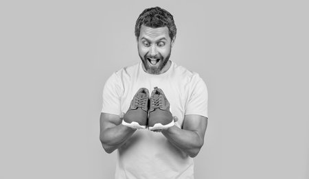 shocked fitness man with sneakers isolated on background. fitness man with sneakersの写真素材