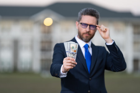 Insurance agent at house sale. Man broker with money. Rent or buy new home. House insurance. Property insurance. Successful broker. Mortgage insurer. American sale manager. Business brokerの写真素材