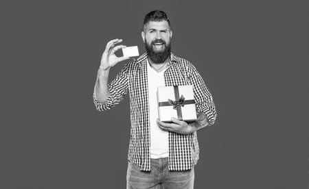 smiling mature bearded man with present box and card
