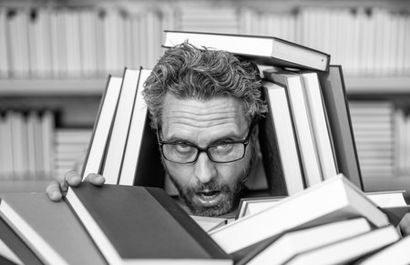 overworked man student reading book in a book store or school library. literature teacher in school...