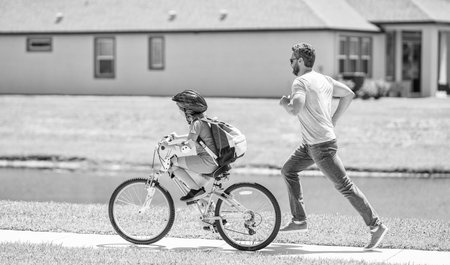 father and son enjoying a bicycle ride together. active son and father duo cycling on bicycle....