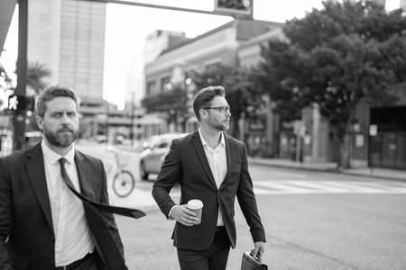 Two successful business men walking outdoor. Businessmen go to work. Business talking. Two businessmen in elegant business suit. Walking colleague. Colleague and friends. Copy spaceの写真素材