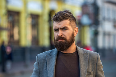 Stylish and brutal man in casual business style. Bearded businessman outdoor. Bearded man wearing...