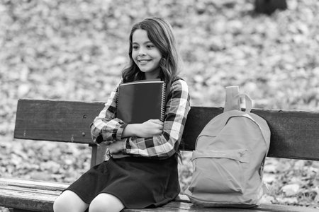 Student girl do homework in autumn. Autumn time to study. School girl get knowledge outdoor. Knowledge day. Autumn day. Back to school. Education and knowledge. School education. Open enrollmentの写真素材