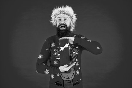 Xmas holiday present. Man at New Year sale. Man hold holiday shopping gift from Santa in studio. Xmas present and gift. Winter shopping sale. New Year and Christmas. Gift wrapping partyの写真素材