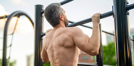Man bodybuilder do pullup exercise. Muscular biceps and triceps. Strong athlete. Man pullup at...