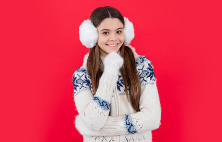 happy teen girl in winter knitwear sweater and headphones in studio.の写真素材