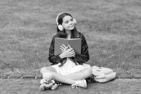 Audiobook. Student girl. School education. Student life. School girl listen audiobook in headphones...