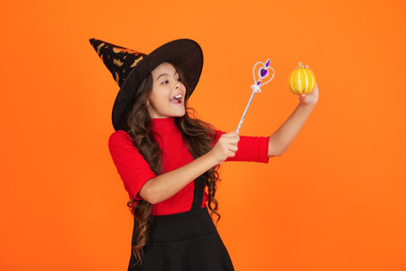 Girl in witch costume hold magic wand. Happy Halloween. Girl witch in Halloween costume isolated on...