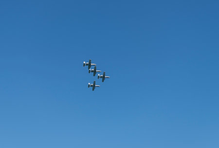 Military air force fighter jet airplane in full flight against blue sky. Four fighter jet in V shape...