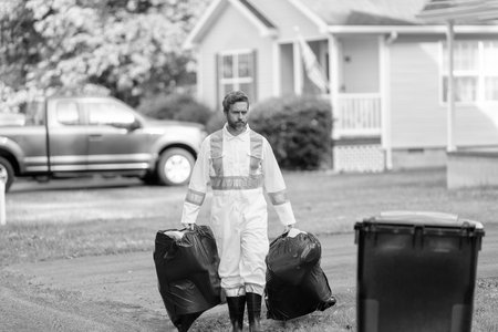 Picking up garbage plastic for cleaning. Keeping garbage plastic into bag for trash. Pollution and recycling. Man putting garbage bag in a trash bin. Environmental protection. Collect garbageの写真素材