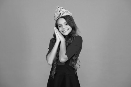 Party princess. Happy birthday. Birthday girl isolated on orange. Teen girl in crown at birthday party. Party celebration. Girlish princess crown. Cute teen girl in princess crownの写真素材