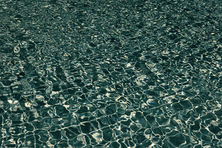 Spa resort on summer vacation. Pool side resort with pool water surface background. Sea ripples on...