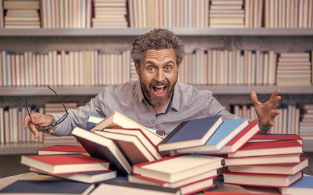 overwork of bookworm. teacher genius in school library. genius studying homework literature near...