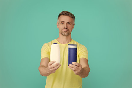 Man use shampoo. Mature man hold hair conditioner. Man with aftershave. Daily habit and personal...