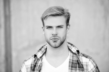 Millennial man wearing checkered shirt. Casual style of millennial man. Portrait of man in casual style shirt. Stylish face portrait of unshaven guy. Handsome serious young man outdoorの写真素材