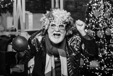 Feast of Christmas. happy man with beard. mature bearded. party man in clown wig. xmas gifts. Time...