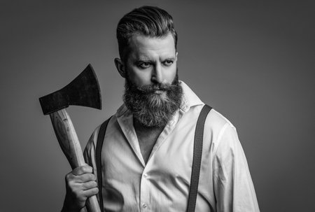 Male fashion style. Vintage guy with axe in retro suspenders. Man in suspenders isolated on grey....