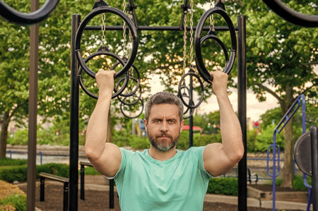 Man pullup at outdoor gym. Muscular man sportsman with strong hands. Sport pullup workout. Sport...