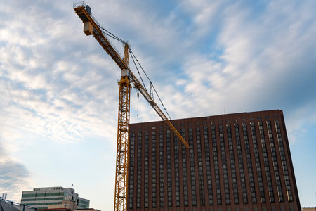 Construction crane at building area. Construction site with building crane. Industrial area. Building and construction. Hoisting crane. Construction at building site with craneの写真素材